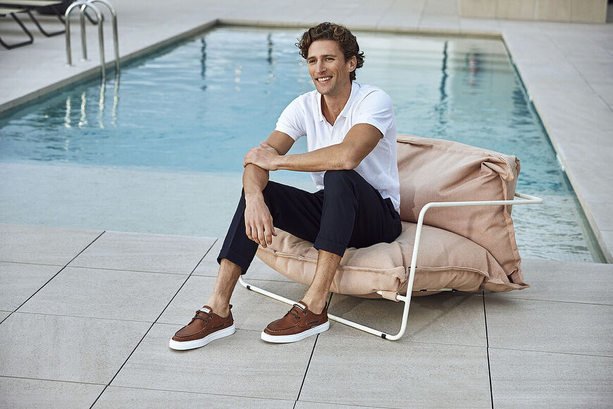 Hombre sentado al lado de una piscina